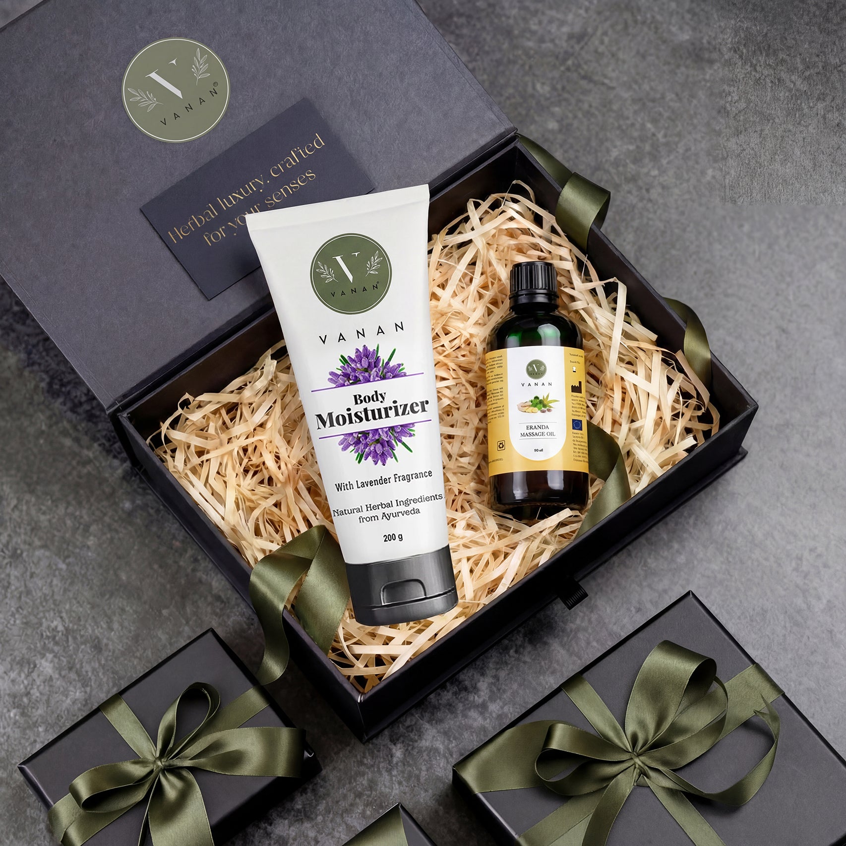 Gift set with Vanan body moisturizer and oil in a decorative box on a gray surface.